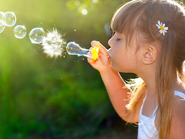 girl-blowing-bubbles-in-sunshine,-dr-dennis-dunne-dds