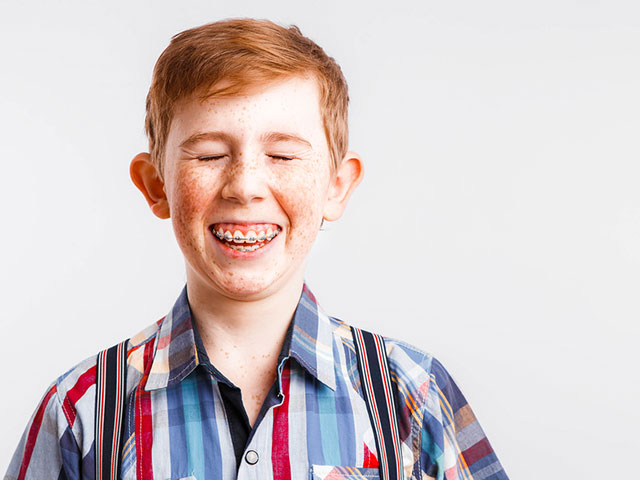 redheaded boy with braces smiling - dennis dunne