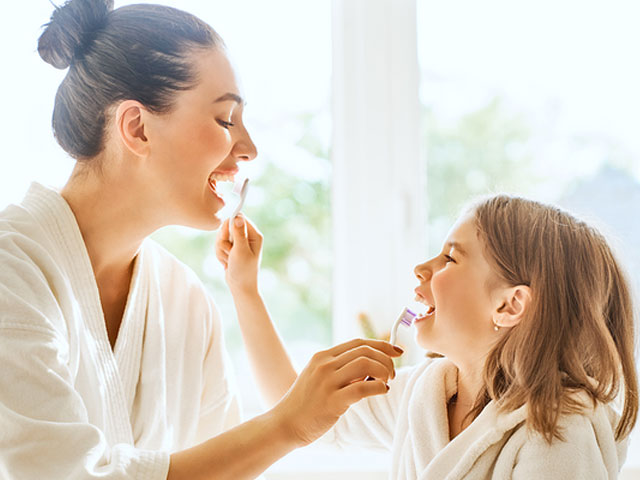 dr-dennis-dunne-mom-and-daughter-brushing-each-other's-teeth