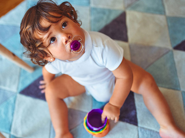 child looking up with pacifier in mouth for dr dunne