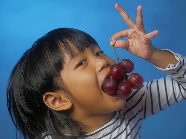 dennis dunne pediatric dentist eugene oregon asian girl eating grapes.