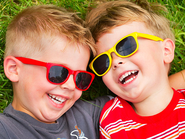 dr.-dennis-dunne,-eugene,-oregon,-two-little-boys-in-grass-laughing